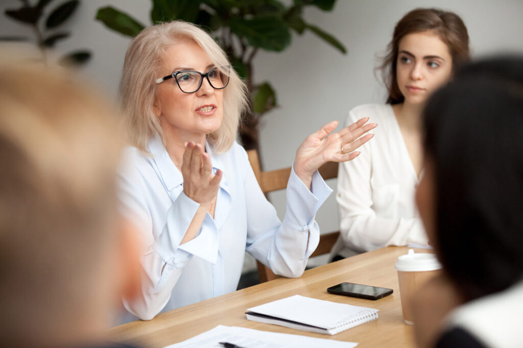 Muture business women showing younger staff how to start a mentoring program