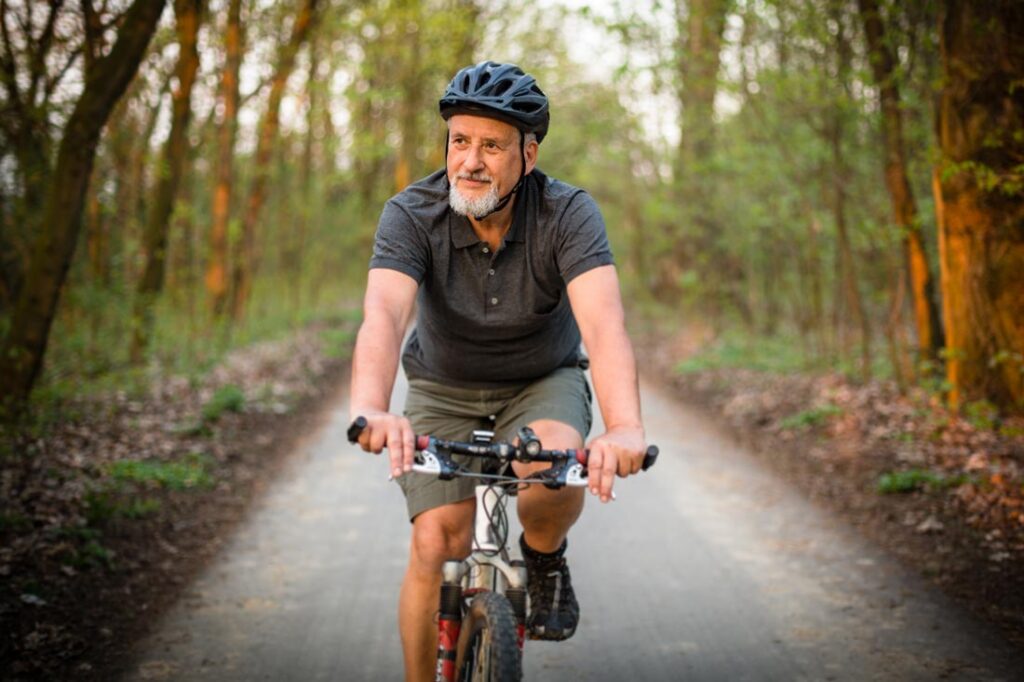 older man riding bike as part of his self-care routine