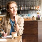 young woman journaling in cafe