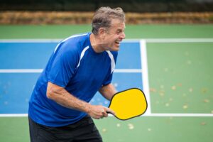 happy man learning new skills to play pickleball