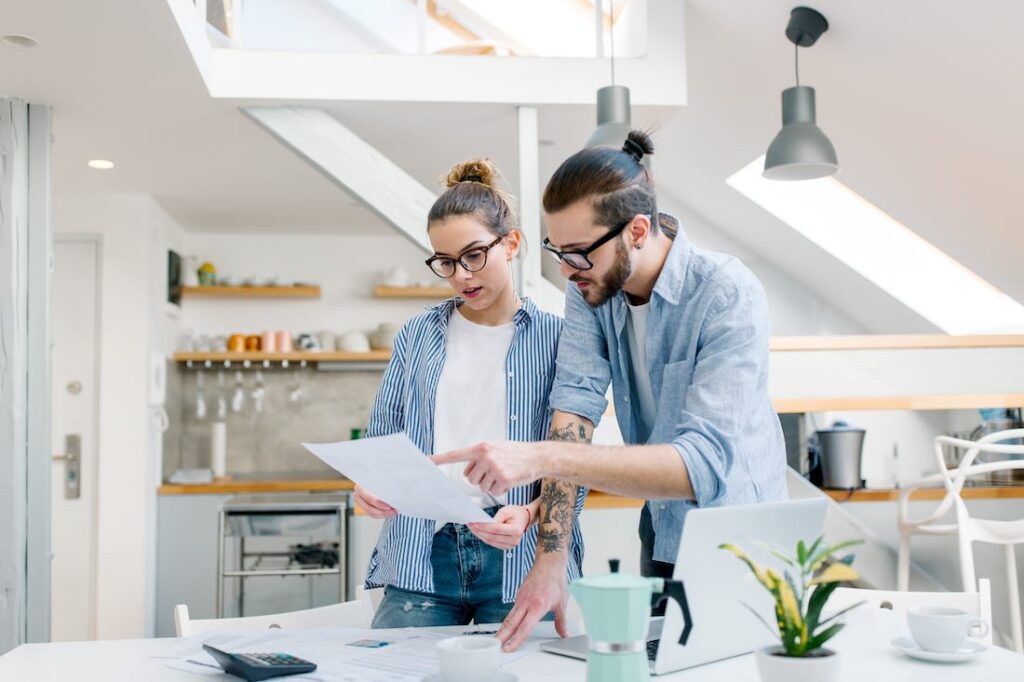 man and woman looking at budget to build an emergency fund