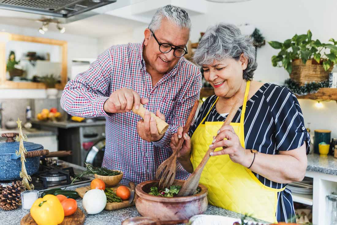 Older couple with healthy eating habits making a salad