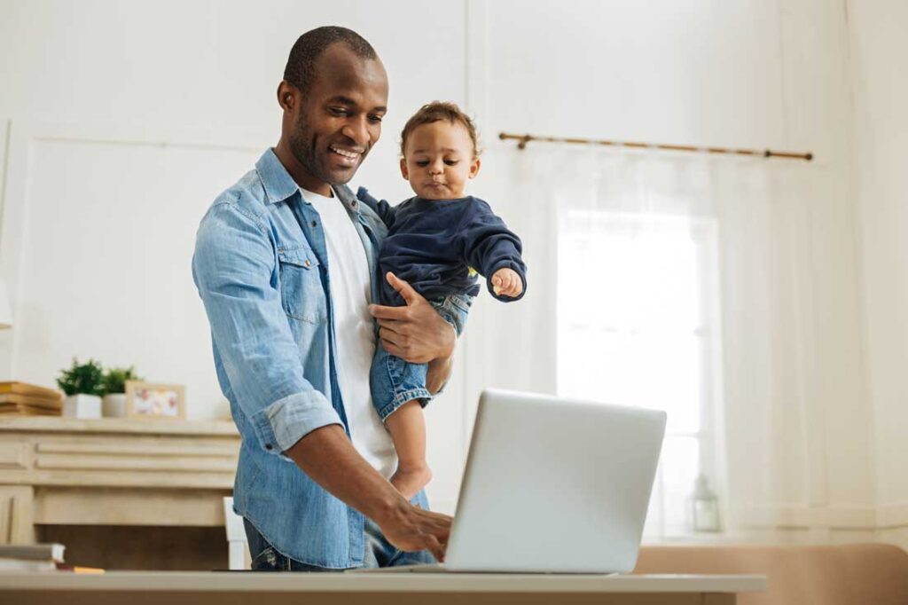 parent holding child while working remotely