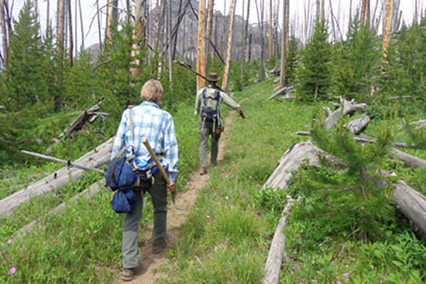 Two hikers taking a restorative vacation to do trail maintenance