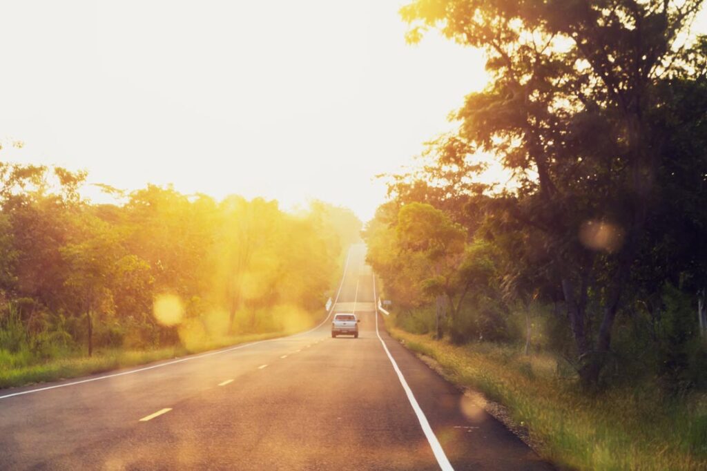 car going down the road at sunset for driving lessons