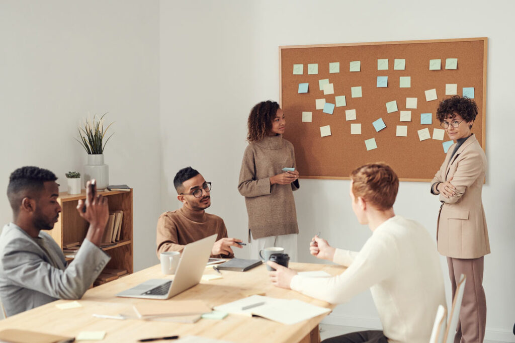 office employees sitting around a table discussing event planning tips