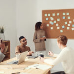 office employees sitting around a table discussing event planning tips