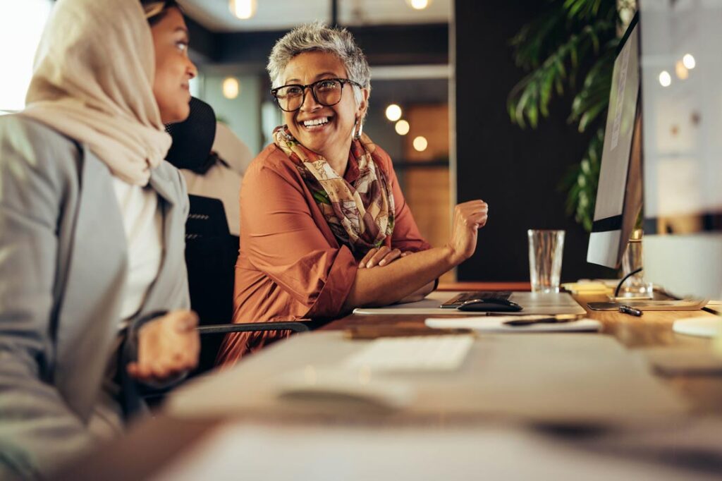 woman experiencing menopause in the workplace smiling at a coworker