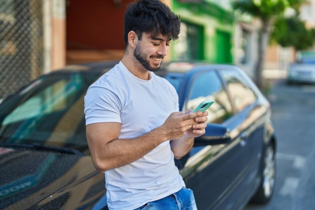 man looking up how to save money on car insurance on his phone