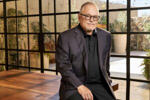 GoDaddy founder Bob Parsons sitting in a sunlit room and smiling at the camera
