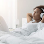 woman relaxing and listening to music using headphones