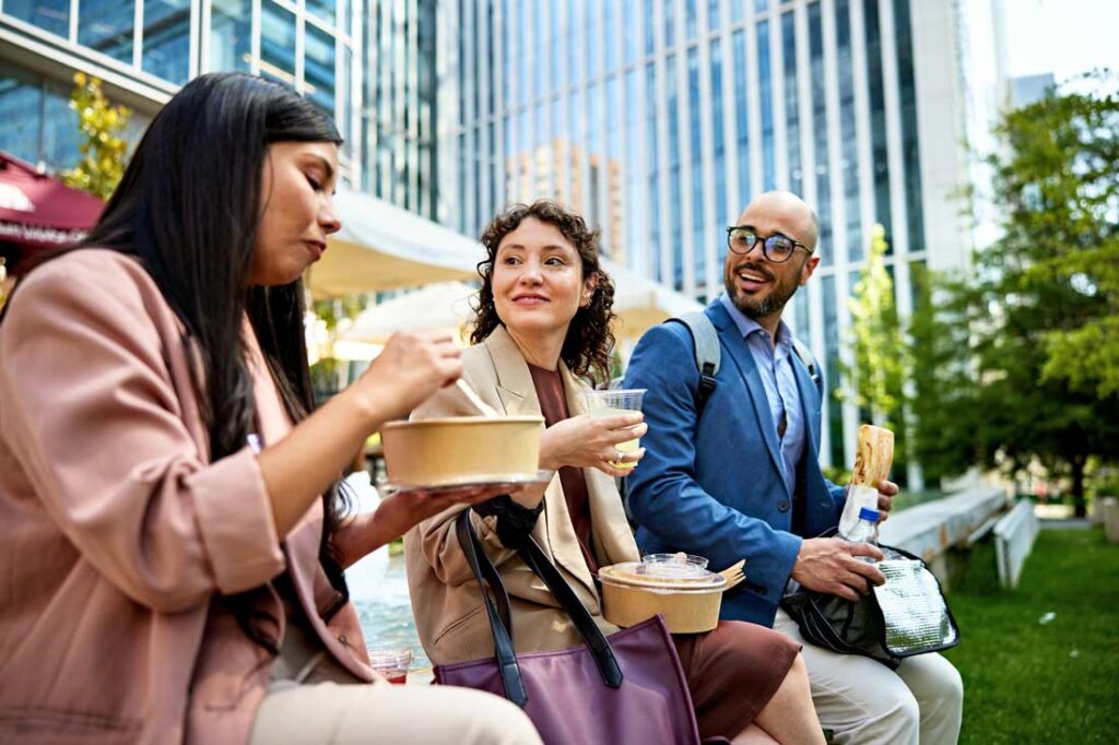 three office employees taking lunch breaks outside