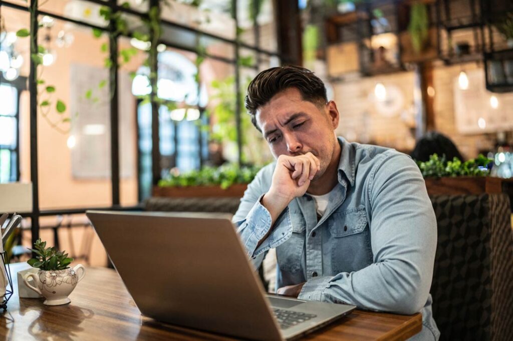 business manager in front of his computer looking frustrated because he's dealing with a toxic client