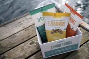 a box filled with bags of kelp food snacks on a fishing dock