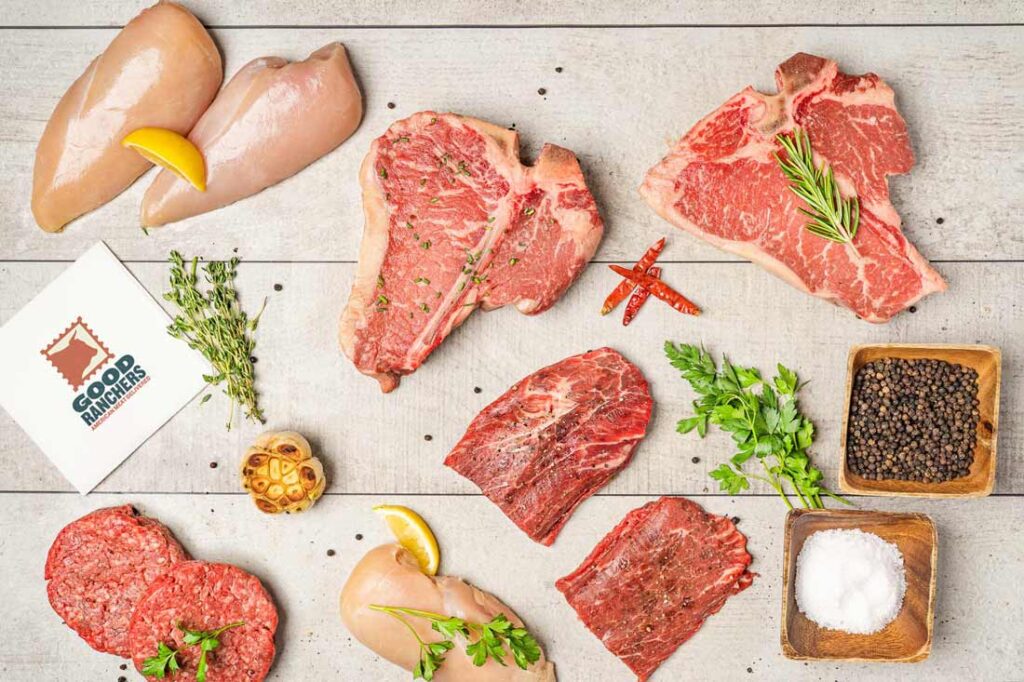 Photograph of different cuts of Good Farmers raw meat including chicken breast, steak, and ground beef patties.