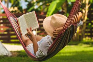 woman reading a book on a hammock after she learned how to truly take time off work