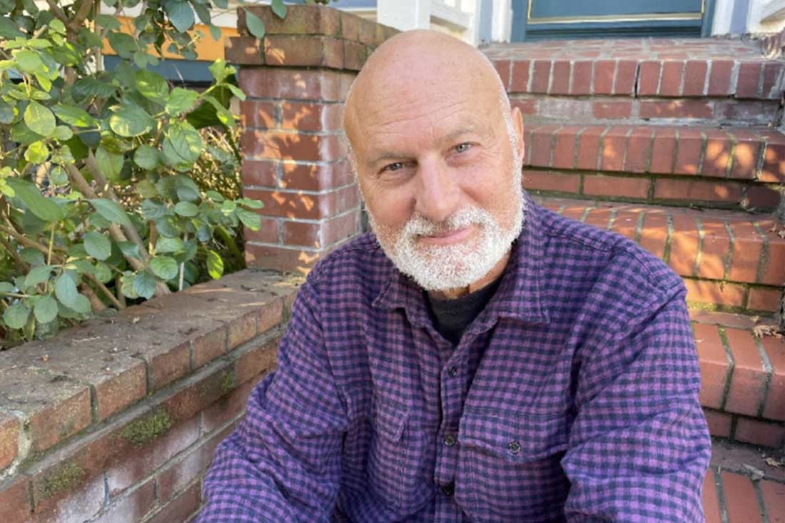 Frederick Marx, filmmaker and author of Turds of Wisdom, sitting on brick steps