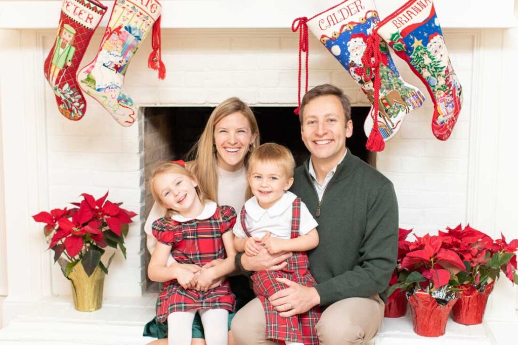 Bauble Stockings founder Kate Stice Stewart and her family on Christmas in front of a fireplace with Bauble Stockings hanging