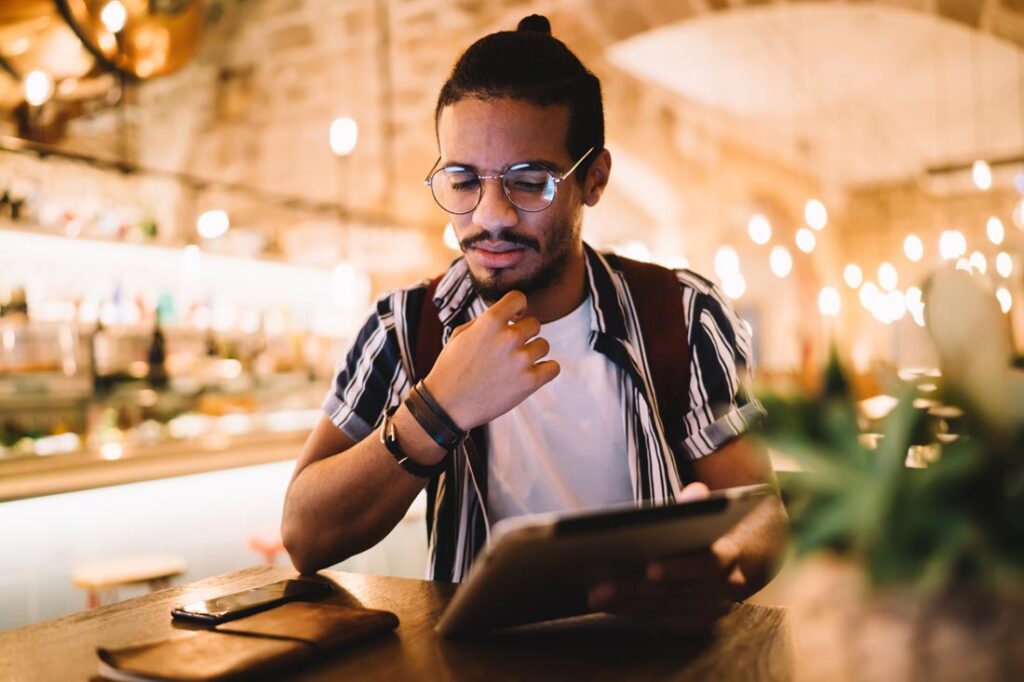 Young Latino man learning how to use chat gpt for business on his tablet