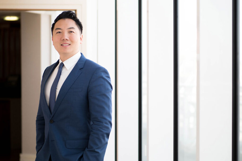 John Lee entrepreneur, motivational speaker, and business coach, smiling in a blue suit
