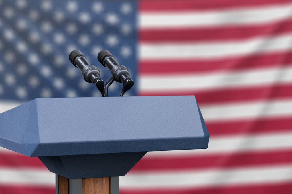 presidential debate podium in front of American flag, a common image during election season for those who are figuring out how to handle politics at work