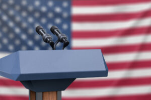 presidential debate podium in front of American flag, a common image during election season for those who are figuring out how to handle politics at work