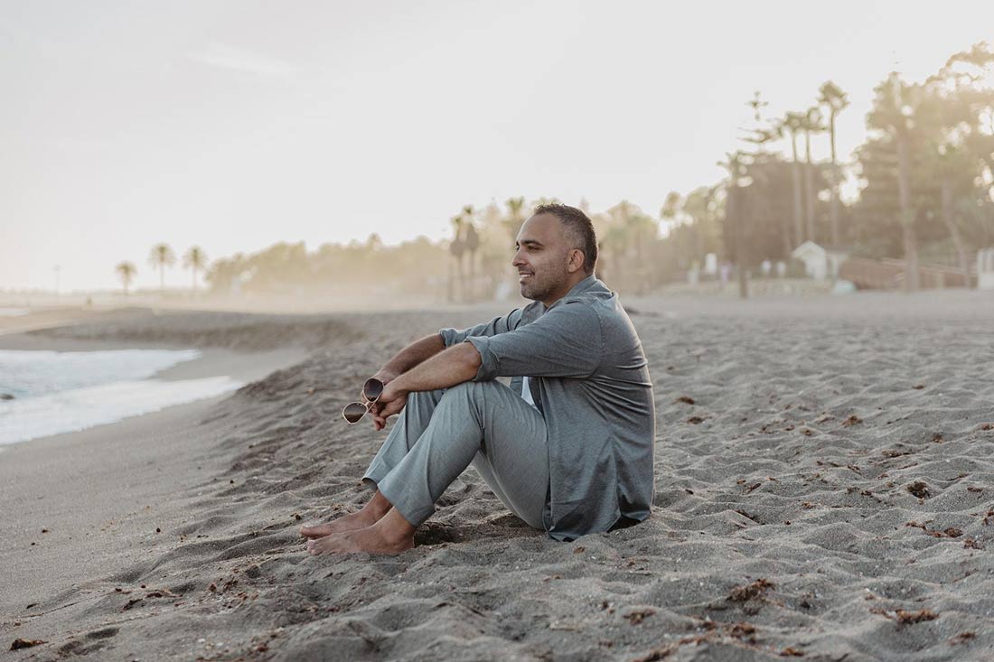 Said Shiripour founder of EZFunnels and The Stray Dogs Center sitting on a beach looking out toward the sea