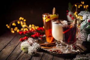 Three of the best Thanksgiving cocktails on a silver tray with Christmas lights behind them