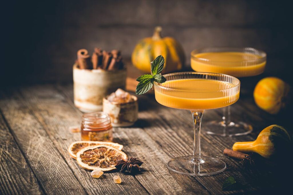 Two orange pumpkin pie non alcoholic Thanksgiving mocktails in martini glasses