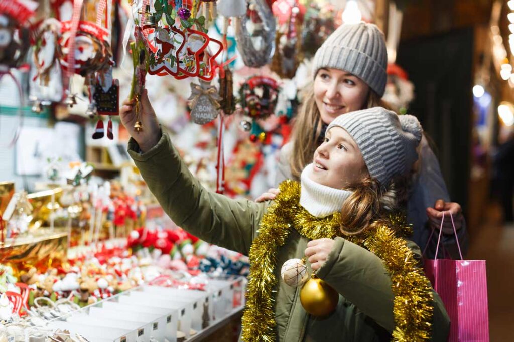 Mother and daughter shopping at one of the best christmas markets