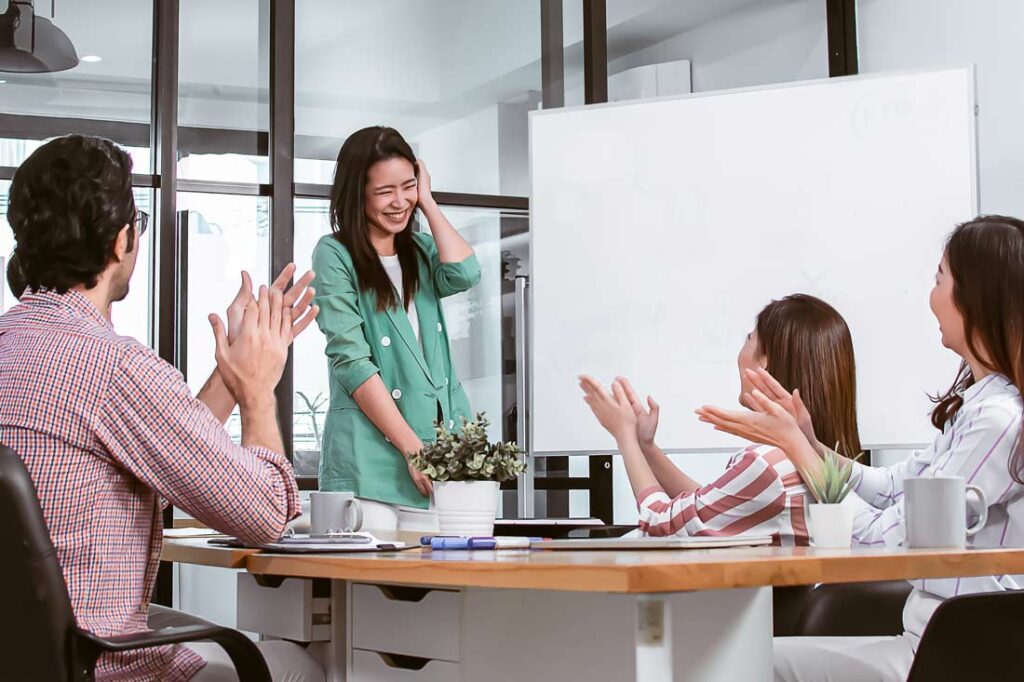 Woman embracing her awkwardness at work in front of her colleagues after reading Henna Pryor's book, Good Awkward, and learning how to be less awkward