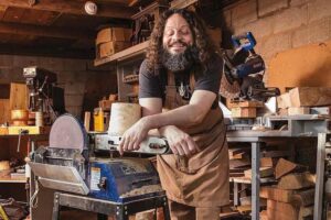 the blind woodsman john furniss smiling in his workshop