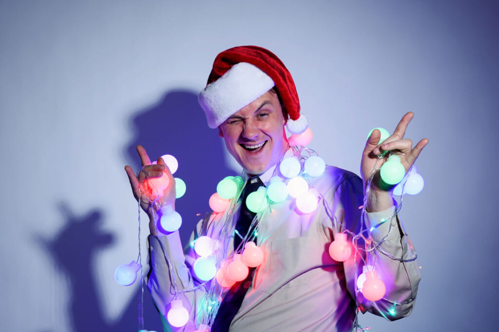 Drunk obnoxious guy with Santa hat on exemplifying what not to do at your office holiday party