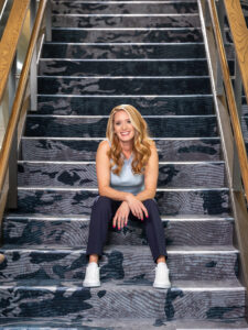 woman sitting on blue carpet stairs
