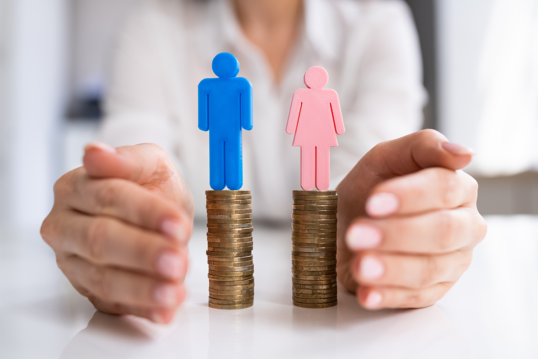 figurines of a man and a woman on top of a stack of pennies to represent the gender pay gap