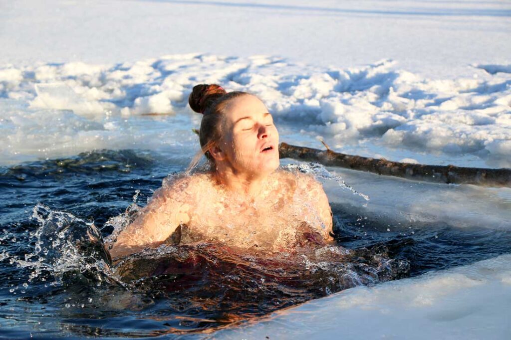 Woman in a cold plunge experiencing cold plunge benefits