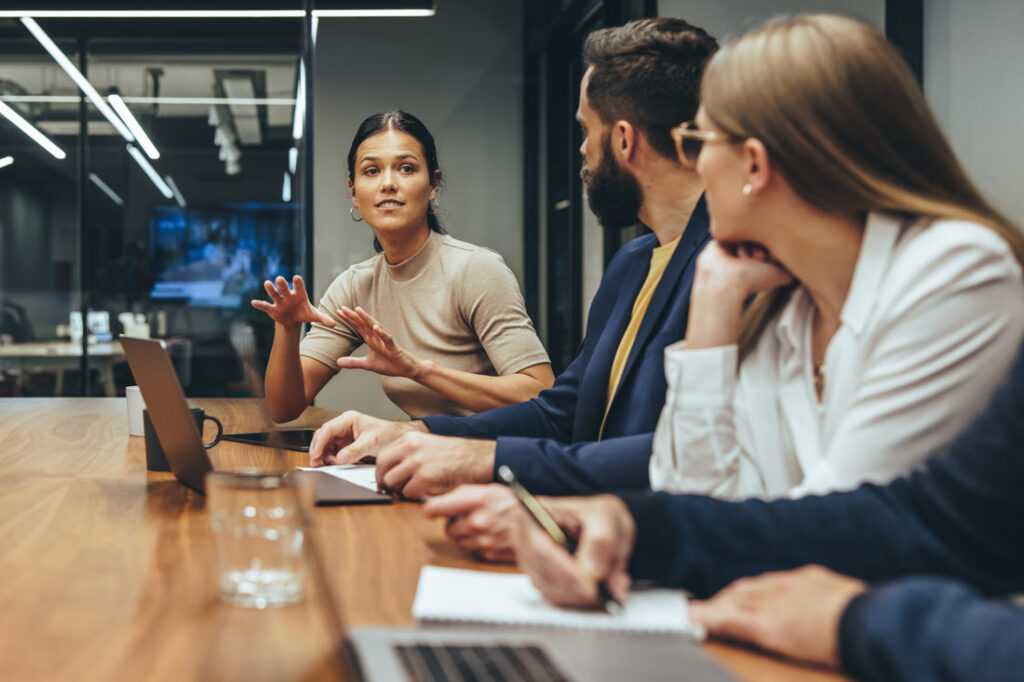 Coworkers engaging in healthy workplace conflict, creative abrasion, in the board room