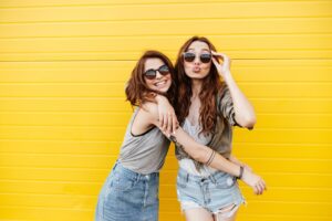 two young women hugging and smiling after meeting through one of the best friendship apps