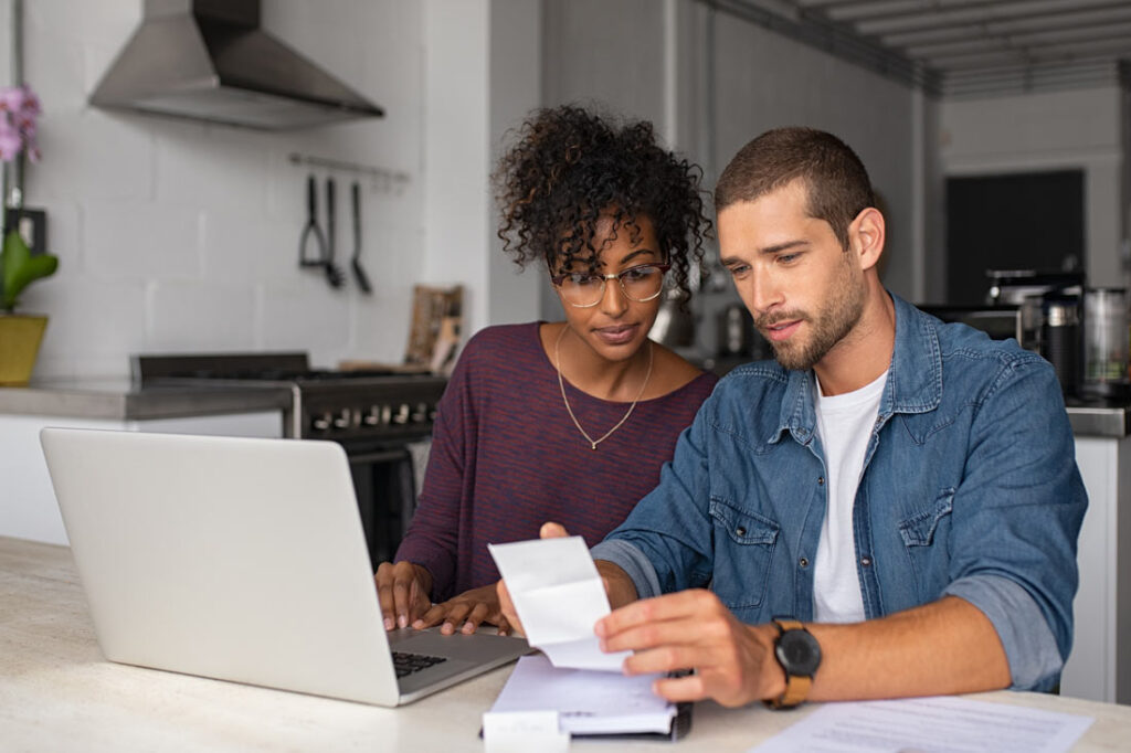 Couple sitting at their kitchen table making financial goals together