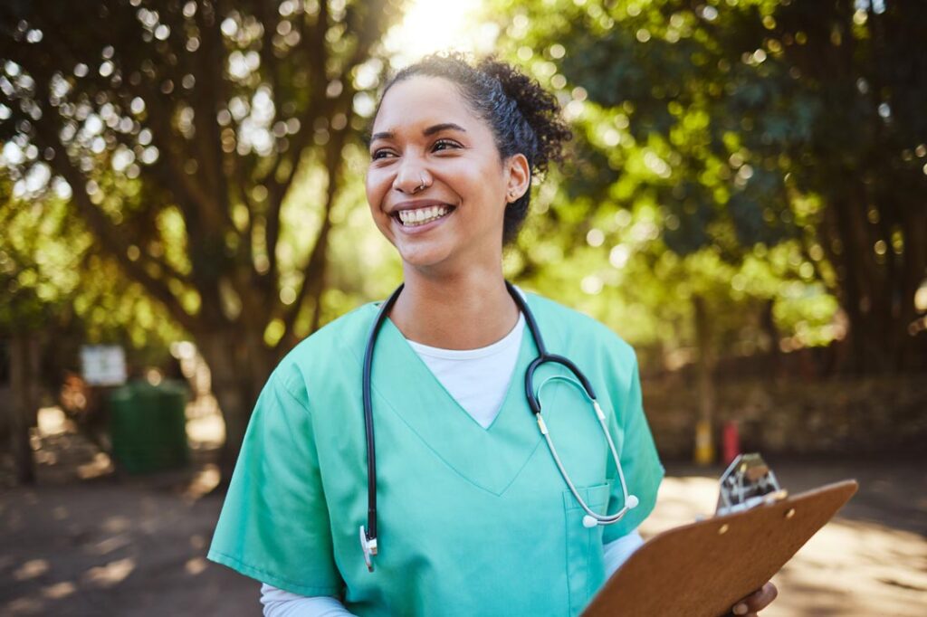 Smiling woman in scrubs holding a clipboard who's starting a nonprofit