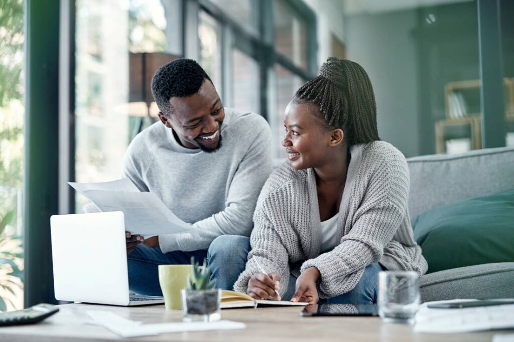 Black couple setting long term financial goals together and smiling