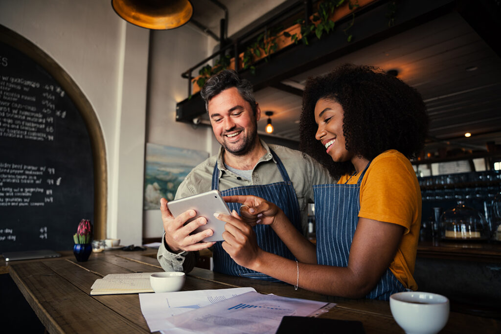 man and woman looking at tablet inside small business