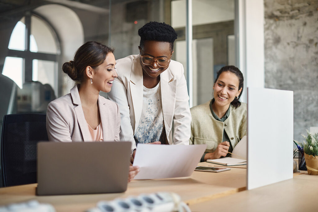 three women looking at laptops