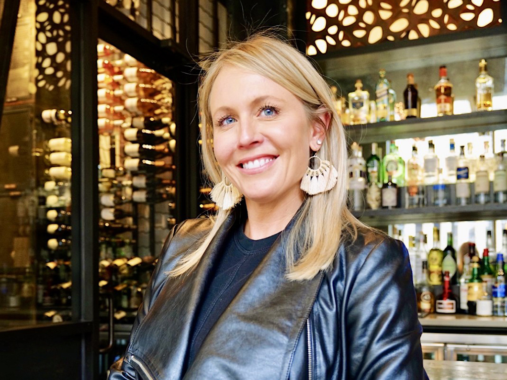 Headshot of Nikki Guard, blonde woman in black leather jacket