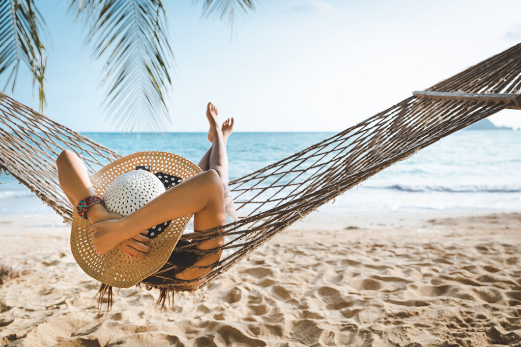 woman on vacation in hammock on beach