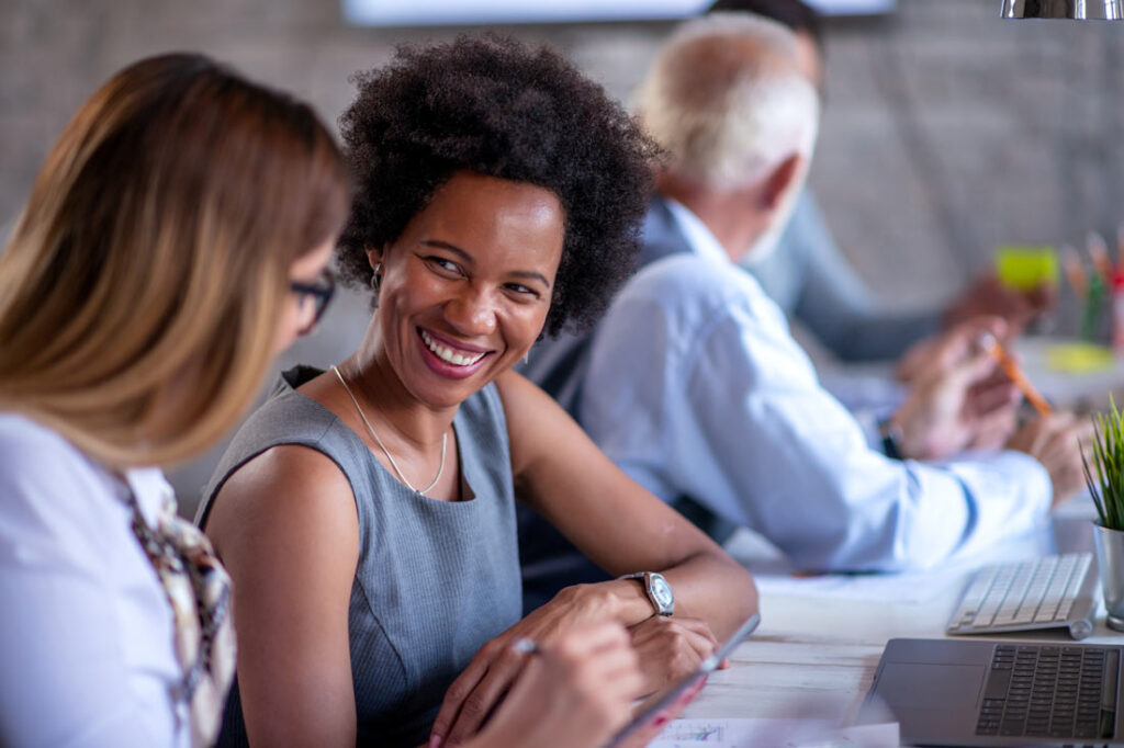 2 female colleagues who bring their whole selves to work laughing together