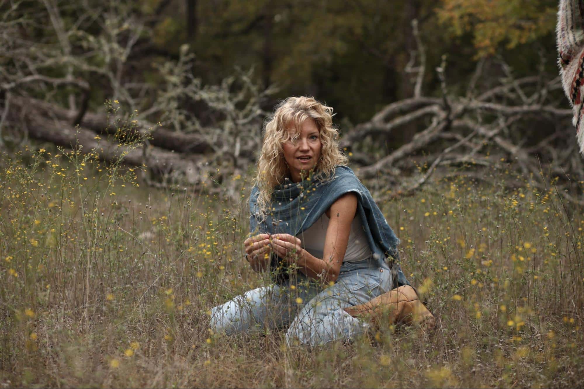 Artist Susie Frazier kneeling in the grass