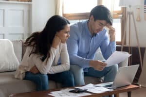 Woman and man stressed while looking at paperwork