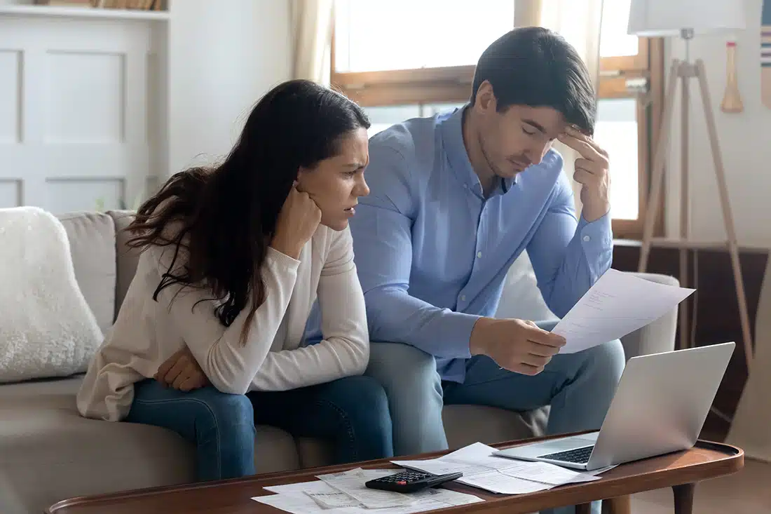 Woman and man stressed while looking at paperwork