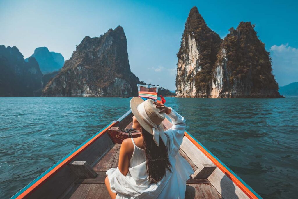 Young women on a boat in a the tropics using Solo travel tips